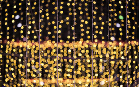 string of light bulbs on yellow abstract backgroundの写真素材
