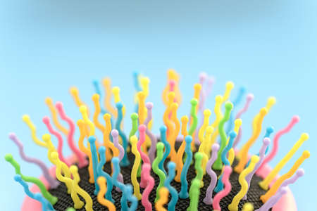 Bright multicolored hair brush on light blue backgroundの写真素材