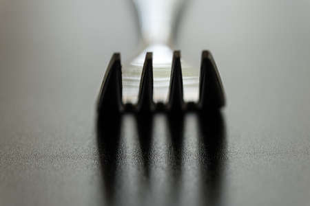 fork on black background. Close-up of stainless fork with copy space.