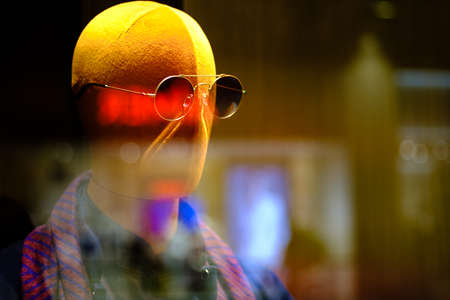 mannequins wear glasses display in window with colorful light reflectionの写真素材