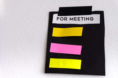 ragged note paper and stripe of adhesive tape on white wallの写真素材