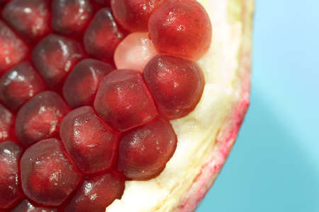 Pomegranate slice with berries on a blue backgroundの写真素材