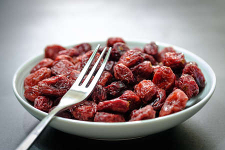 Closeup of a White plate Full of Dried Cranberriesの写真素材