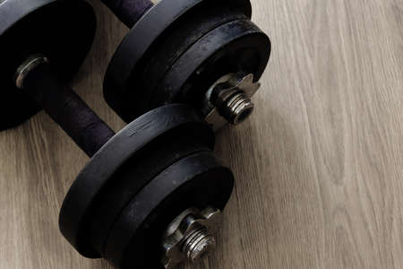 black color old rusty dumbbells on wood floorの写真素材