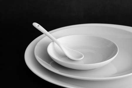 Set of plates with spoon on black tableの写真素材