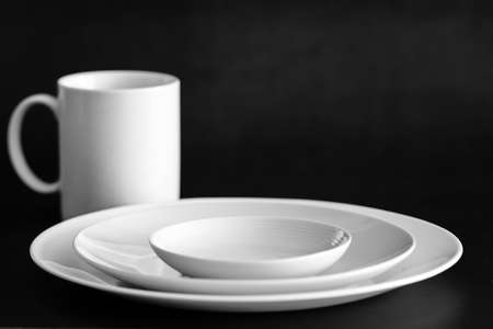 Set of plates with cup on black tableの写真素材