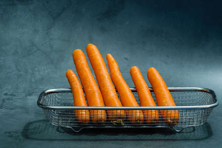 fresh baby carrot in basket isolated on black backgroundの写真素材