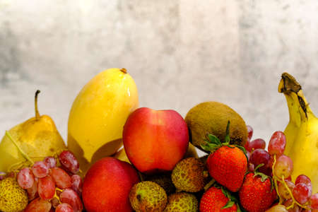 Assortment of exotic fruits in metal basket isolated on whiteの写真素材