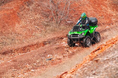 Rider driving in the quadbike race in winter in the forest