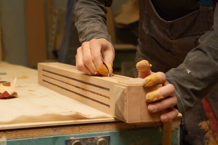 Young carpenter making wooden parts for the production of wooden furniture, joiner's shop workの写真素材