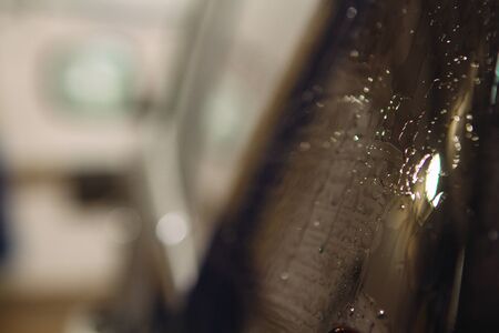 An employee of the car wash thoroughly washes conducts detaling and applies protective equipment to...