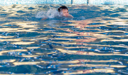 young man bathes in poolの写真素材