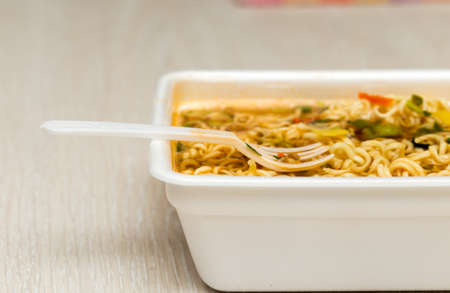 Raw food noodles quickly with a fork on the tableの写真素材