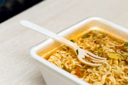 Raw food noodles quickly with a fork on the tableの写真素材