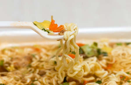 Raw food noodles quickly with a fork on the tableの写真素材