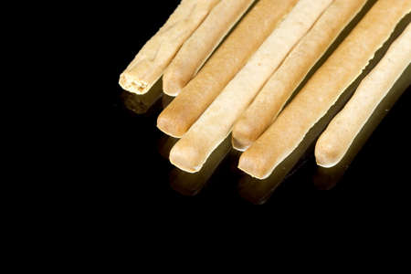 Delicious crispy pastry sticks isolated on black