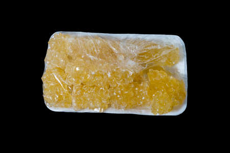 yellow rock sugar and rock sugar cane in a plastic bowl on a black backgroundの写真素材