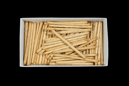 crunchy biscuit sticks on a cardboard box isolated black backgroundの写真素材