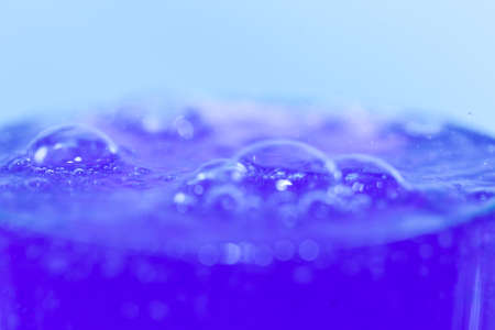in a glass of blue cocktail with bubbles close-upの写真素材