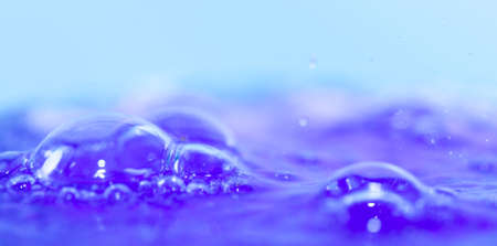 in a glass of blue cocktail with bubbles close-upの写真素材