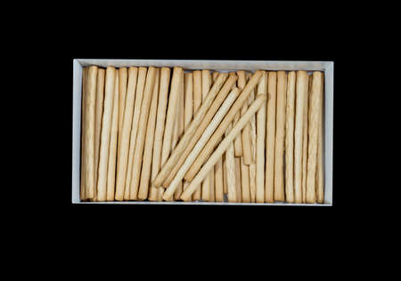 crunchy biscuit sticks on a cardboard box isolated black backgroundの写真素材