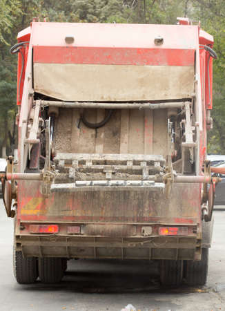 Garbage truck keeping garbage on urban street.