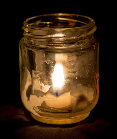 candle lit brightly against a black backgroundの写真素材