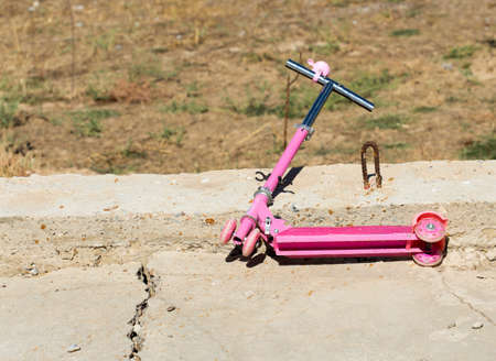 Children's pink scooter in the yardの写真素材