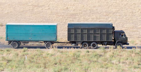 Truck passing by on a green agricultural fieldの写真素材