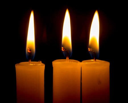 candle lit brightly against a black backgroundの写真素材