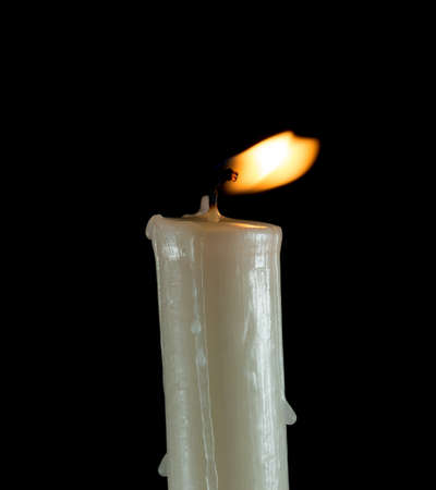 candle lit brightly against a black backgroundの写真素材