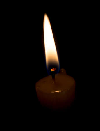 candle lit brightly against a black backgroundの写真素材