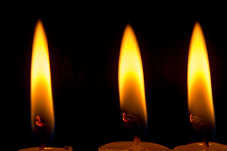 candle lit brightly against a black backgroundの写真素材