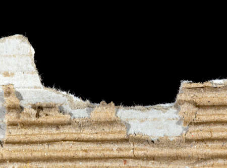 Ripped cardboard on black backgroundの写真素材