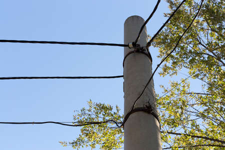 electric pole power lines and wires with blue skyの写真素材