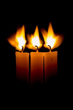 candle lit brightly against a black backgroundの写真素材