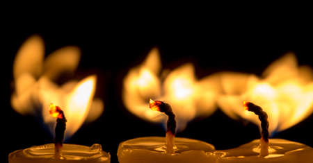 candle lit brightly against a black backgroundの写真素材