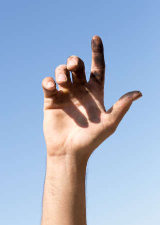 Dirty hands against the blue skyの写真素材