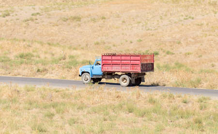 Truck passing by on a green agricultural fieldの写真素材