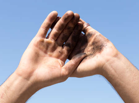 Dirty hands against the blue skyの写真素材