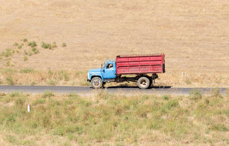 Truck passing by on a green agricultural fieldの写真素材