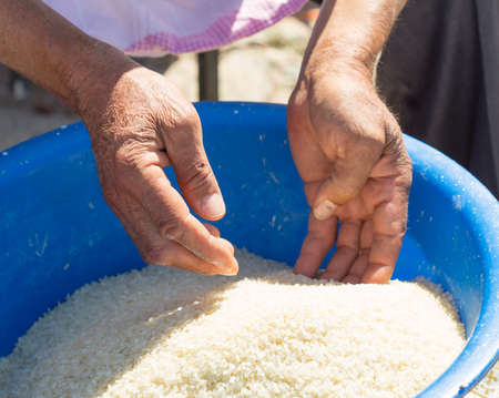 man cleans rice for pilafの写真素材