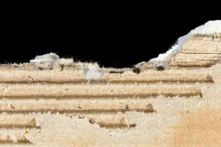 Ripped cardboard on black backgroundの写真素材