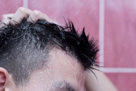 Asian handsome young man bathing in bathroomの写真素材