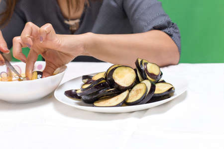 Girl preparing food on a table from eggplantの写真素材