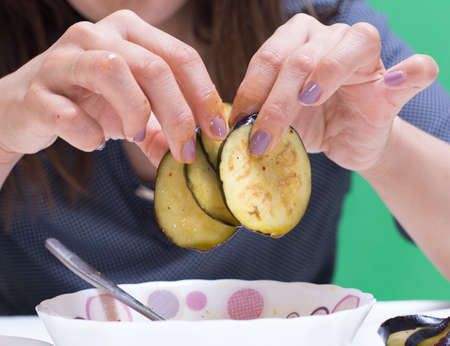 Girl preparing food on a table from eggplantの写真素材