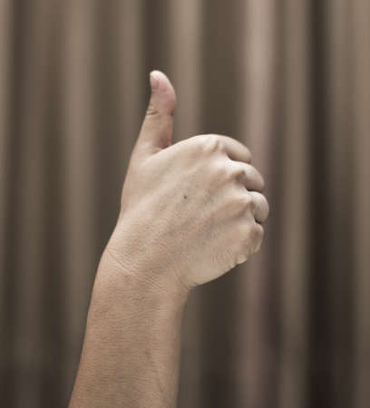 Hand of a man on a background of brown clothの写真素材