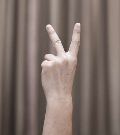 Hand of a man on a background of brown clothの写真素材