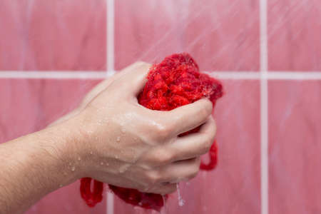 A person bathes in the shower with a washclothの写真素材