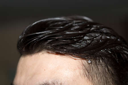 hair combed back to a young man's head close-upの写真素材